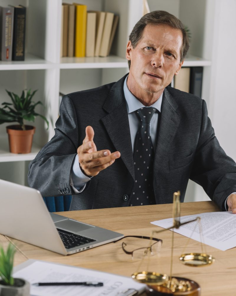 abogado-maduro-sentado-en-la-sala-de-audiencia-gesticular